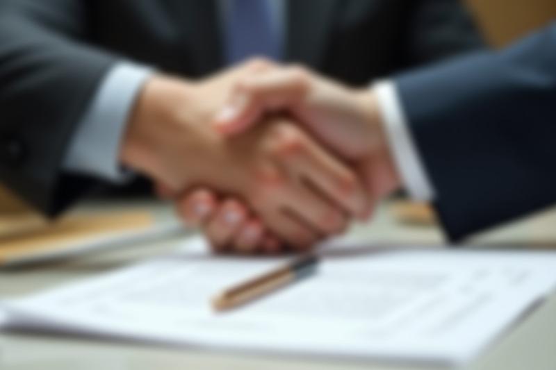 صورة ليدين تتصافحان فوق عقد